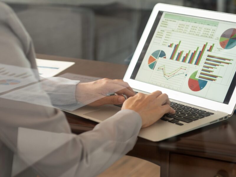 someone working on a computer with finance graphs on the screen